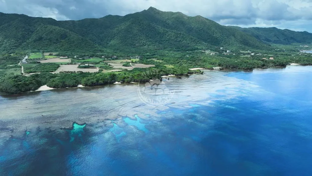 山、街、サンゴ礁がつながる風景